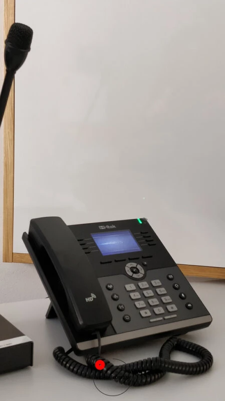 Telefono VoIP da tavolo con display e microfono a collo di cigno per comunicazioni in ambienti professionali